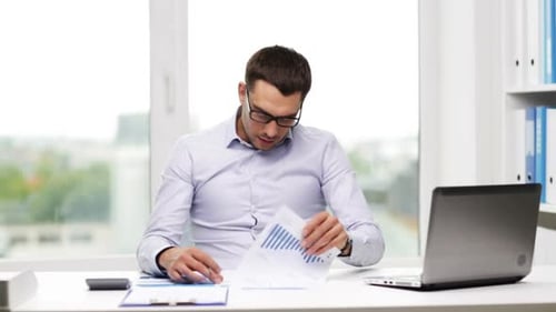 растерянный предприниматель с документами и ноутбуком