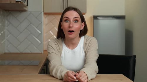 Woman Reacts with Surprise, Then Smiles While Talking