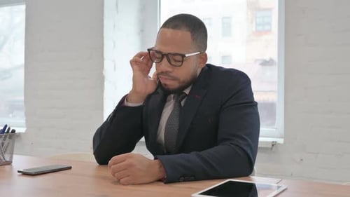 Mixed Race Businessman having Headache while Sitting in Office
