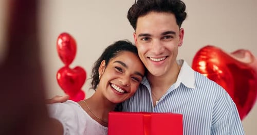 Smiling Couple Poses with Red Gift Box