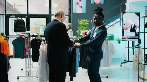 African American Store Assistant Helping Regular Client with a Suit