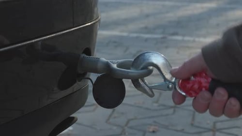 Hand Attaching Tow Rope Hook to a Car for Recovery