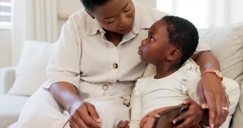 Woman and Child Using Phone Together on Couch