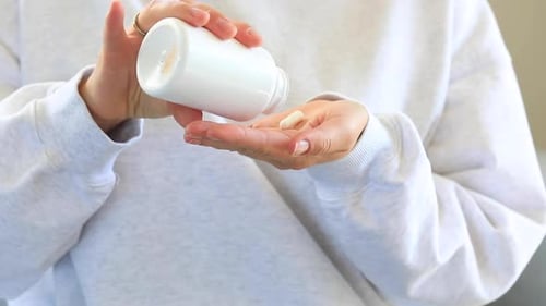 Pills Poured Into Hand From a Bottle