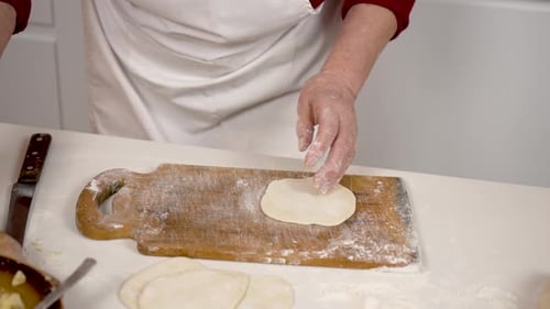 Person Preparing Dough and Filling at Counter