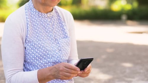 Senior Woman Using Smartphone Device Outdoors