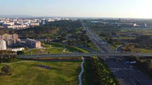Stylistic drone shot starting on a vista of a vast highway system and ending on a close-up of of a