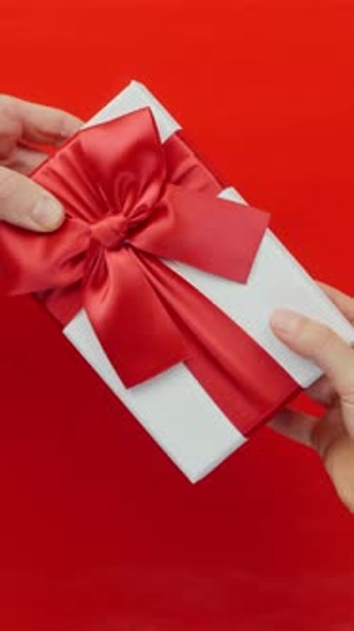 Hands Exchange White Gift Box with Red Bow