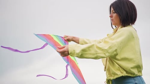Woman Holds Colorful Kite Smiling Outdoors