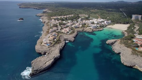 Small town in rocky coastline in Mallorca, Spain. Still shot aerial view