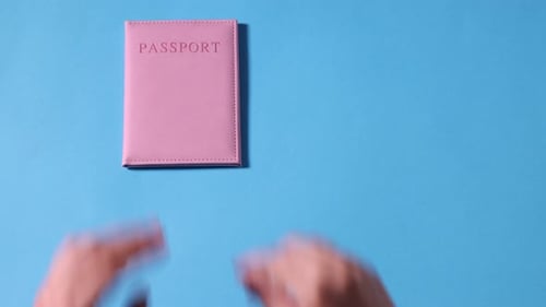 Woman putting passport, airplane model and flight ticket on light background, top view