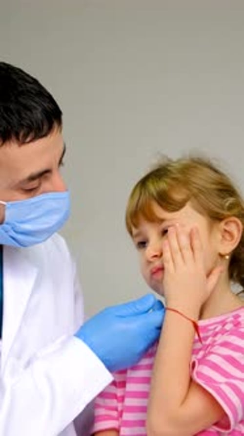Doctor Examining Young Girl's Throat in Medical Clinic