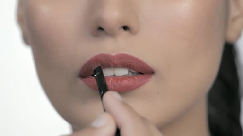 Woman Applies Red Lipstick with Makeup Brush