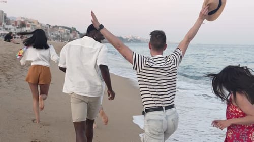 Young Friends Having Fun Running on the Beach Near the Sea at Sunset Lifestyle Travel Holiday