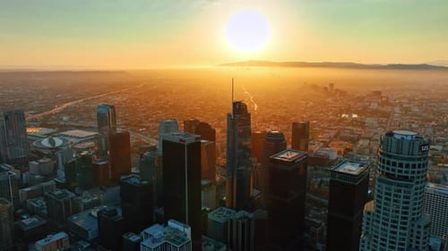 Flight over the high-rise downtown of Los Angeles, California, USA at sunset.
