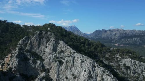 The Camera Flying Off Over the Mountain and Offers a View of Mountains Behind It