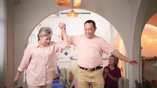 Joyful Senior Couple Dancing with Friends in Living Room