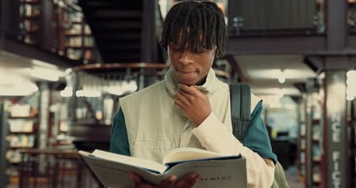 Studying, student and man with book, library and planning for assignment in university or education