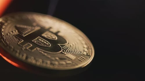 Close Up of Gold Bitcoin Coin Spinning on the Black Background