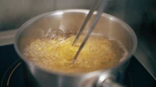Closeup in a Professional Kitchen Chef in Black Gloves Prepares Pasta Stages of Preparation