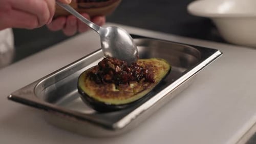 Skillful Person Using Spoon to Topping Sauce on Eggplant