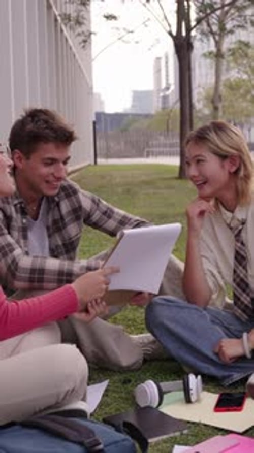Group of Young International University Students Sitting on the Grass Outside the Faculty Building