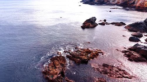 Aerial View of Rocky Coastline with Waves Crashing