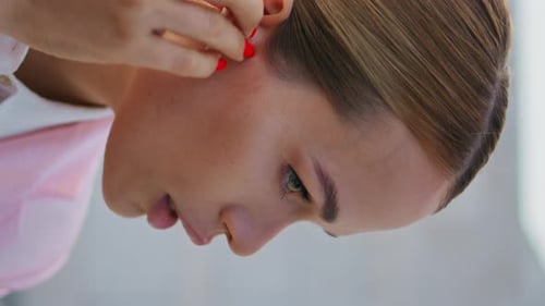 Woman Inserts Wireless Earbud in Close Up