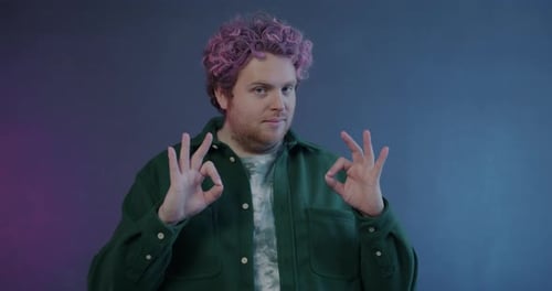 Smiling Man with Pink Hair Makes OK and Thumbs Up
