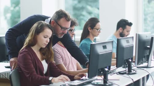 Der Lehrer hilft den Schülern im Computerunterricht während der Vorlesung.