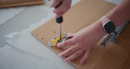 Woman Assembling Furniture with Screwdriver