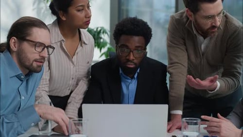 Professionals Collaborating on Laptop in Modern Office