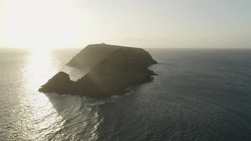 Super bright sunlight from sunrise at scenic island Ilhéu de Cima, aerial