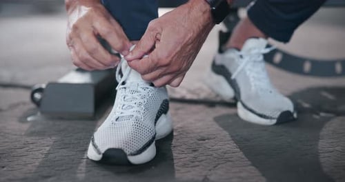 Fitness, hands of person and tie shoes in gym before cardio workout, endurance training or marathon