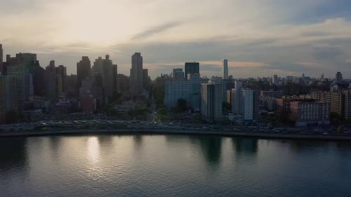 centering aerial shot towards the sunset over upper Manhattan, New York City, over the East River. V