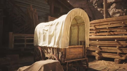Wooden Wagon Covered with Canvas Situated Inside a Rustic Barn Setting