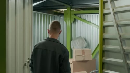 L'homme entre dans l'unité de stockage et l'organisation des boîtes de départ