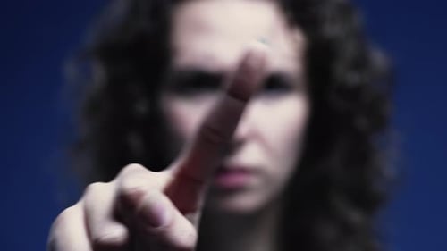 Upset woman pointing finger to camera saying NO by waving in rejection. Close-up of negative body