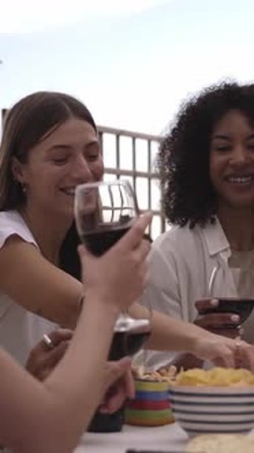 Celebration of a Group of Friends Gathered at a Table on a Rooftop Terrace Sharing and Having Fun