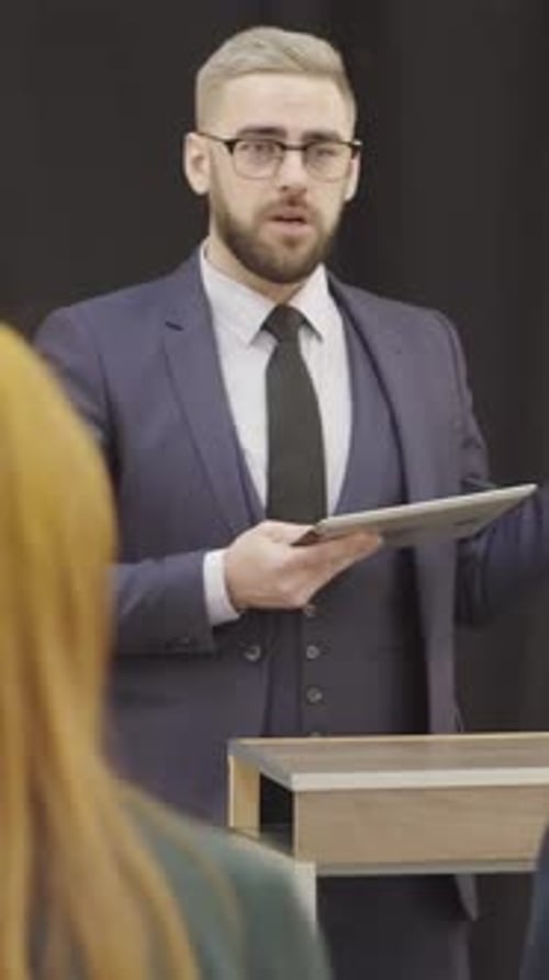 Man in Suit Giving Presentation to Audience