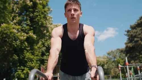 Man Doing Dips Outside on Sunny Day