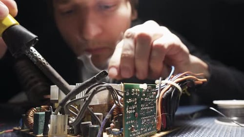 Man Soldering a Circuit Board Close Up