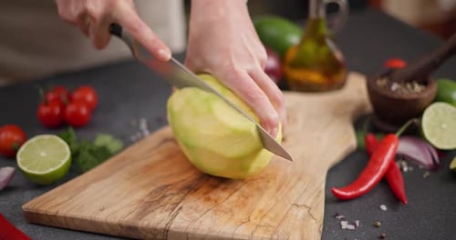 Hands Cut Fresh Mango on Cutting Board