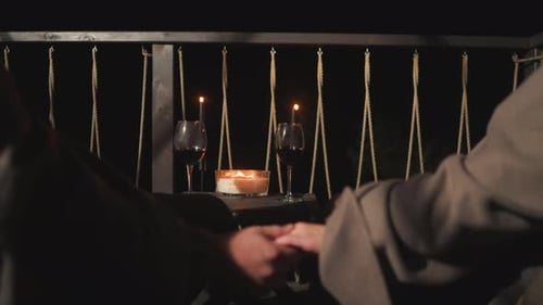 Romantic Couple Holding Hands at Night with Candles