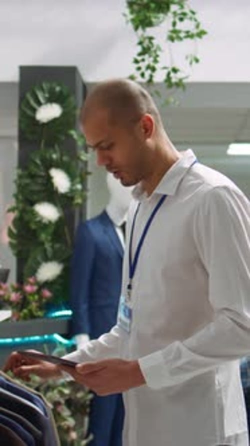 Store Employee Using Tablet Checking Inventory in Clothing Store