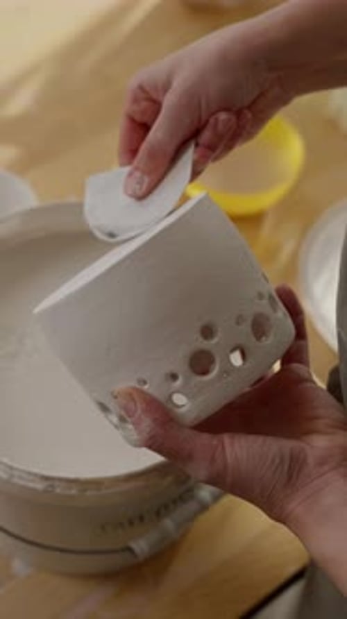 Hands Smoothing Ceramic Pot in Pottery Studio