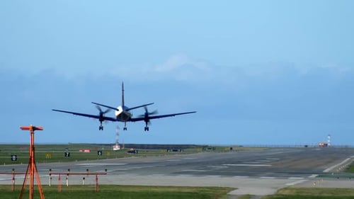 A Turboprop Propeller Airplane Touching Down on the Runway, Rear Shot.