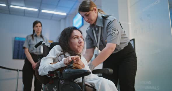 Female TSA Officer Checking Woman with Physical Disability in Airport ...