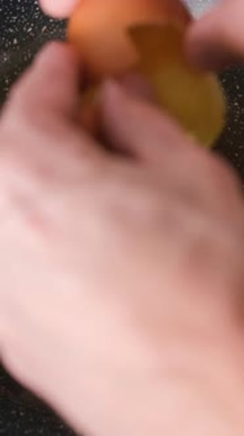 Closeup of Cracking Eggs on Pan Frying