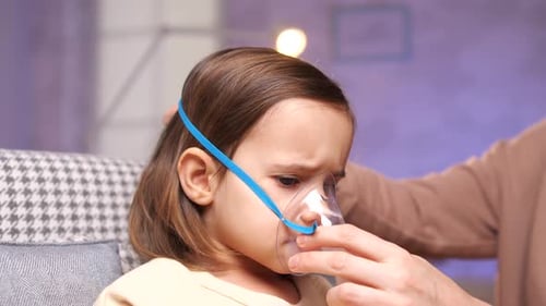 Child Using Nebulizer with Assistance Indoors